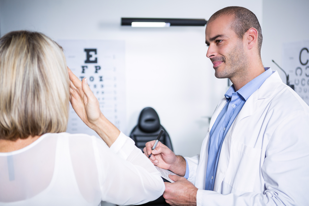 Diagnosing Legal Blindness What is legally blind? Male optometrist taking eye test of female patient in ophthalmology